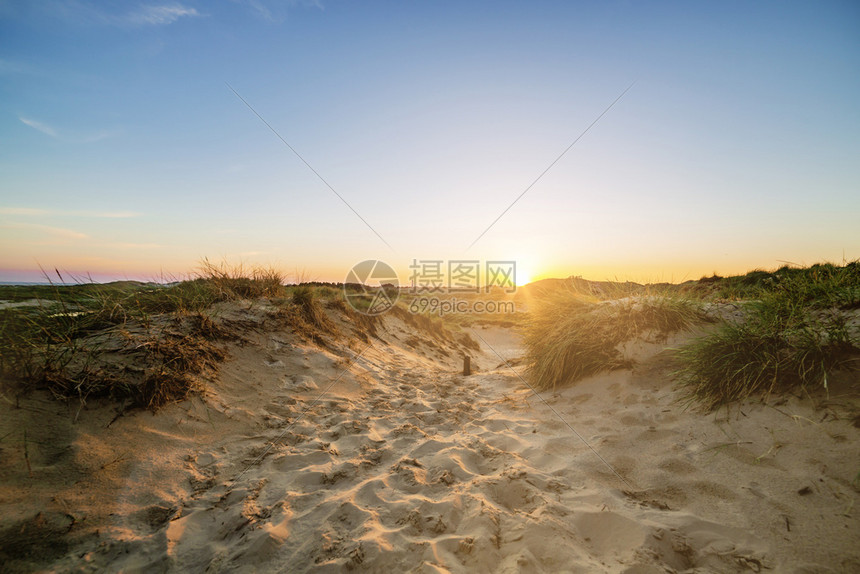 宽的夜晚太阳在阿姆鲁沙丘上空弗里西亚夏天图片