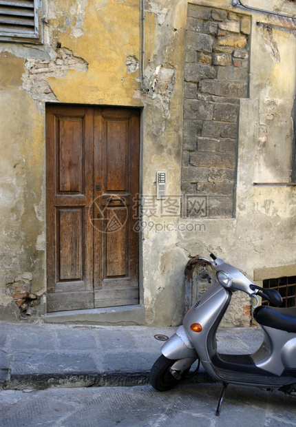在意大利佛罗伦萨一所住宅的木门外等待摩托车通勤欧洲风化图片