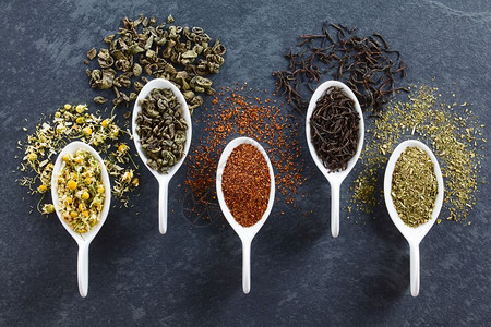茶叶盐绿色rooibos黑茶和交叶上各种松散的干茶叶在干板上的头部拍照红灌木洋甘菊衬套图片