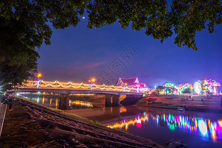 公园南河上美丽的灯光晚上在泰国Phitsanulok市的Naresuan桥上快速地旅游图片