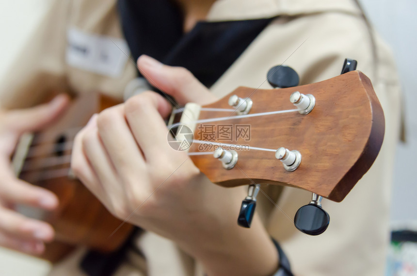 歌曲仪器UkuleleeUkulelele女孩的手玩Ukulele已经赢得了许多受欢迎的Ukulelele最终从夏威夷本土文书转图片