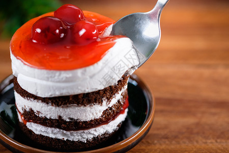 巧克力蛋糕草莓樱桃和白奶油在木制桌子上缝合盘糖果投标图片