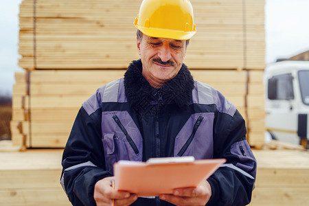 专业的Caucasian高级男子建筑工一般人建筑承包商的肖像他们身着黄色保护头盔手持钢笔和现场数据报告项目文件核对检查男人行业图片