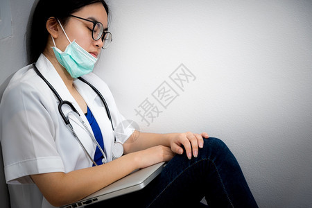 劳累过度亚洲年轻女医生戴面罩安全到科罗纳坐在角落地板上睡在角落地板上沉睡着疲劳过度动的概念注意自己是帮助医生阻止Covd19的流图片
