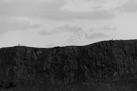 黑暗的夏天在苏格兰爱丁堡的亚瑟斯柯普座落火山岩和两名不明身份的人中黑白两面的戏剧景象受欢迎的图片