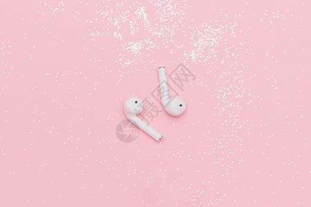 白无线蓝牙耳机和粉红色纸背景模板上的彩色涂鸦用于文本或设计字您的平坦上方视图复制空间新西比尔斯克俄罗2019年3月日白色无线蓝牙图片