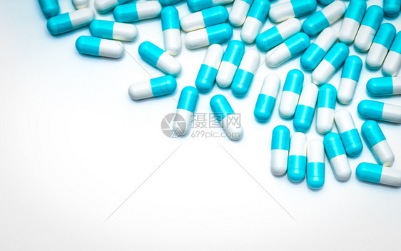 白色的药品背景上的蓝抗生素胶囊丸用于医疗保健主题的彩色胶囊丸制药业抗生素耐概念抗菌物剂学医疗的图片