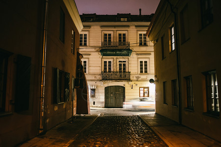 立陶宛历史的狭窄古老夜晚有旧建筑和冬季背景的维尔纽斯街图片