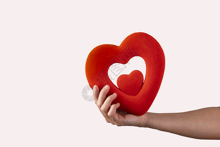 季节快乐的象征女人手里握着红色的心在白背景上概念情人节图片