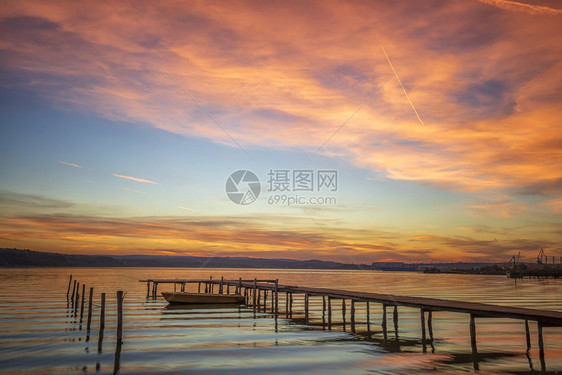 海岸大日落有木头码和船景观旅行地平线图片