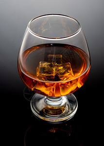 木头酒精托米斯平杯子和威士忌在黑色背景的Tumbler玻璃杯上威士忌在黑色背景上图片