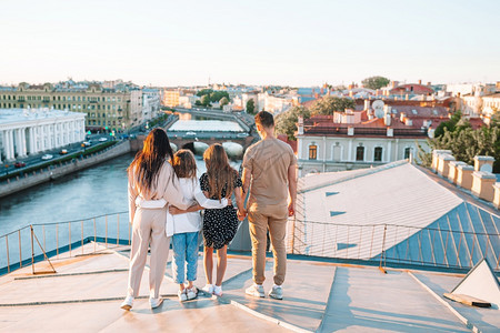 老的遗产旅游四口之家在欧洲城市度假一家在屋顶上享受着俄罗斯圣彼得堡美丽的日落景图片