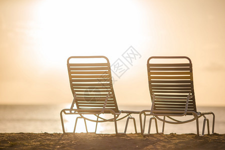 夏天马尔代夫美丽的热带海滩上白色休闲椅在黄夕阳下美丽的热带海滩上美丽的休息椅奢华风景优美图片