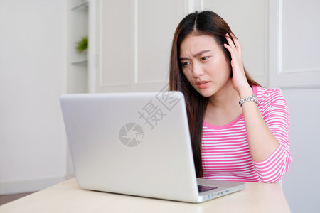 在使用笔记本电脑工作在家临时办公室生活方式时表达沮丧的年轻青女亚洲妇的情绪失落技术担心自由职业者图片