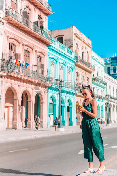 在古巴哈瓦那流行地区古巴旅游女客的流行街上古巴年轻女旅行者笑着后视线回过头来校对Portnoy目的地中央首都图片