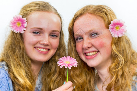 抓住摆姿势两个caucasian少女笑着带粉红花朵长发有色图片