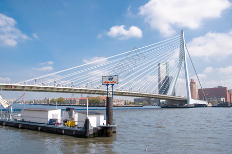 纪念碑位于荷兰鹿特丹的Erasmus桥和背景中的商业建筑摩天大楼支撑图片