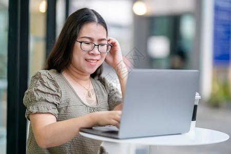 吸引人的商业技术在咖啡店用笔记本电脑咖啡杯和智能手机如背景通信概念等工作的女散校对Portnoyunorg图片