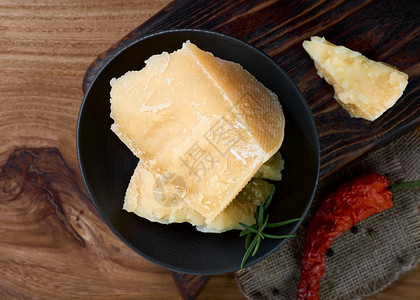 食品平坦的黑色盘子里干酪片黑盘里有薄香料和干酪奶片红色的图片