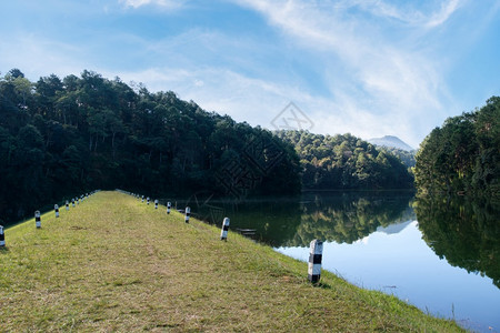 乡村地区灌溉系统在山谷中小水库的脊大坝上自然通道白云和蓝天空于上午开始农村地区灌溉系统的自然通道植物岭风景图片