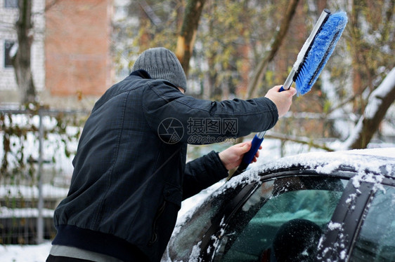 工具冷冻天气冬季雪汽车冬季问题一个穿着黑色夹克和手套的男人明显手在特殊的刷子帮助下用它把车从雪中打扫干净图片