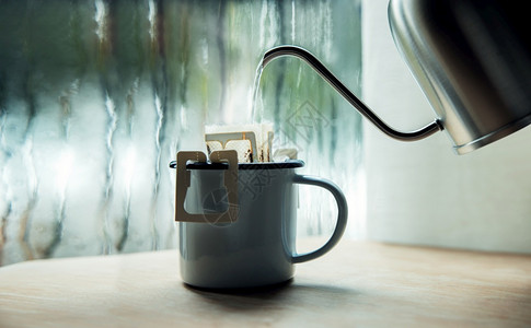 清晨雨天的将热水从壶倒入即时咖啡桶放松与和谐生活方式共享快乐的生活方式以热水饮用窗口冲洗咖啡筛选进入窗户图片