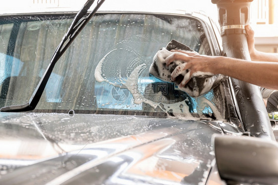 水肮脏的洗车工作人员正在用海绵清洗汽车挡风玻璃清理车辆的挡风玻璃闪耀图片