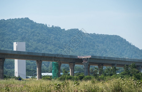 正在沿山区建造双轨项目高架铁路桥通往河谷的小城镇前视与复制空间接连着一面的铺路图户外高架桥农村图片