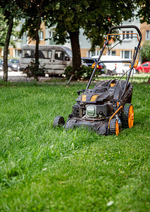 现场割草机特写工人在地上割草照料花园使用汽油割草机工人在地上割草使用汽油机男维护园艺图片