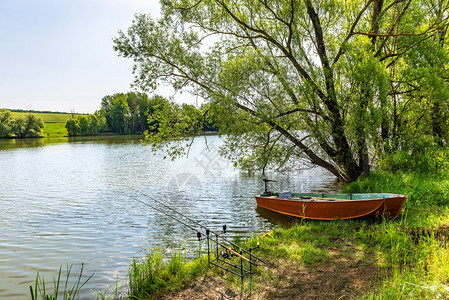 春天信号钓鱼竿和河边停泊的旧船钓鱼竿和河边的船早晨图片