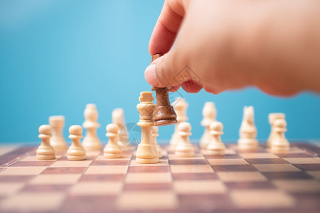 拥有棕色国王象棋结对竞争手并赢得比赛的商人之手领导才能的概念必须有一个商业策略和竞争对手在中的评分在竞争中必须有一个商业战略和竞图片