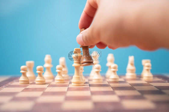 拥有棕色国王象棋结对竞争手并赢得比赛的商人之手领导才能的概念必须有一个商业策略和竞争对手在中的评分在竞争中必须有一个商业战略和竞图片
