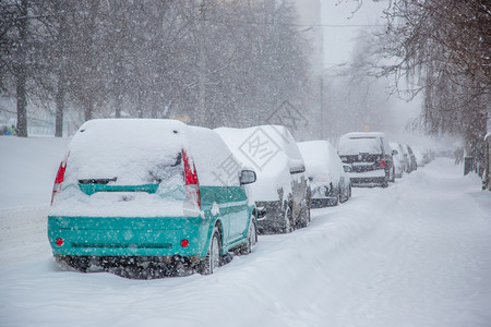 冬季暴风雪中停车场被覆盖的辆城市道路和街被雪覆盖停车场冬季暴风雪中被覆盖的车辆气候冻结白色的图片