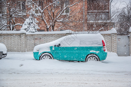 降雪冬季暴风中停车场被覆盖的辆城市道路和街被雪覆盖停车场冬季暴风雪中被覆盖的车辆冰花图片