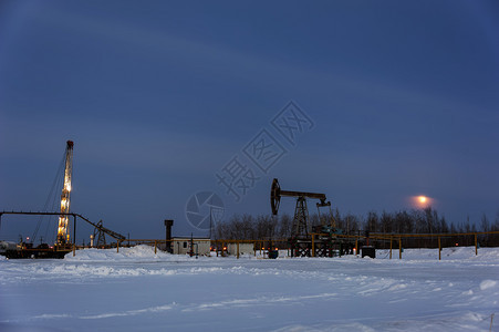 行业机器工具在油田的泵千斤顶冬天日落空背景石油开采概念泵千斤顶石油开采概念图片