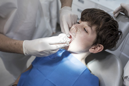 牙医检查小男孩的牙齿图片