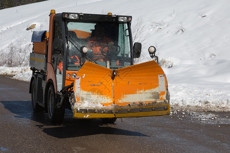 橙色红雪犁在路边操作与缘的白黄色雪一道工作在路上操与边缘的白颜色雪犁一起工作景观车图片