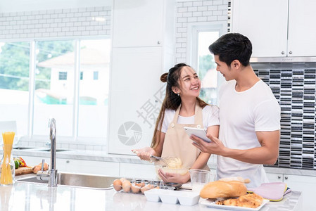 乐趣亚洲夫妇一起在家厨房做饭和烘烤蛋糕爱与幸福概念蜜月和情人节主题甜美的蜜月和情人节主题厨师女孩图片
