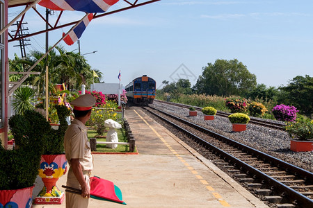 火车站长已准备好发出信号特别快车正在泰国北部线的当地车站通过该正经泰国北部线的地方车站警卫服务乘客图片