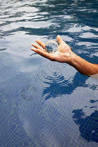 人手握着玻璃球在水面上日出手指假期图片