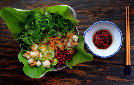 最美景苦瓜沙拉有紫色卷心菜胡萝卜炸面包花生和烤肉素食蔬菜加酸甜或健康饮的餐盘越南人用黑木吃女士简单的草本图片