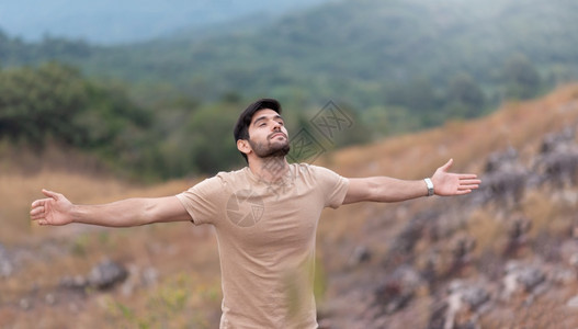 平衡早晨一个人享受着无忧虑的自由在然背景上张开双臂在山顶屏息着呼吸新鲜空气的怀抱人眼闭着睛拥抱大胡子图片