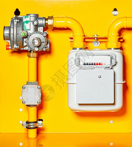 柜台工业的花费安装在黄色背景墙壁上的煤气计压缩器和管道复制有黄色背景的减少器空间天然气表图片