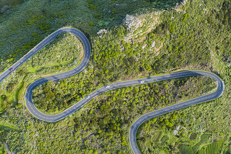 天线摄影经过山上一条有树木和岩石的连线蛇纹公路空中顶端风景图片
