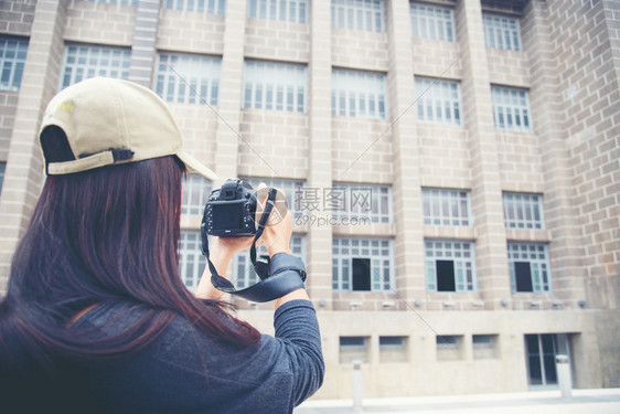 年轻女旅行者背包和照相机在旧城的老区美丽女人背着字游客士老的图片