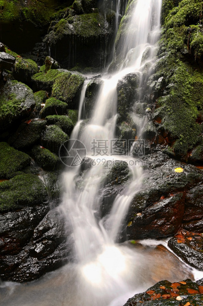 自然在小溪上美丽的瀑布天然多彩背景森林的石头上有自来水山干净的公园图片