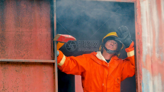消防员用水管化学泡沫喷洒剂发动机与火焰战斗的消防员Fierman戴硬帽身穿防火灭器方面的营救训练制服难的财产软管图片