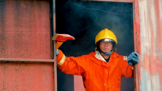 保护难的身体消防员用水管化学泡沫喷洒剂发动机与火焰战斗的消防员Fierman戴硬帽身穿防火灭器方面的营救训练制服图片