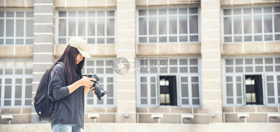 亚洲人旅游者使用dslr专业摄影机在度假旅行时使用Dslr专业照相机的亚洲旅游者年轻女旅行者携带背包和照相机前往老城美丽的女士背图片