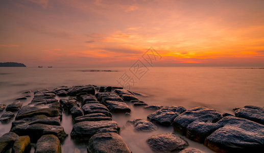 戏剧水海景日落时在石滩上的岩美丽海边夕阳天紫光海与空黄昏时的热带海风云天空和日落抽象背景平静放松生命景观图片